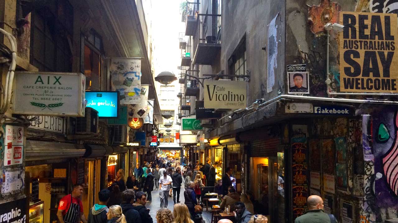 A laneway lined with restaurants and shops in downtown Melbourne is crowded with patrons