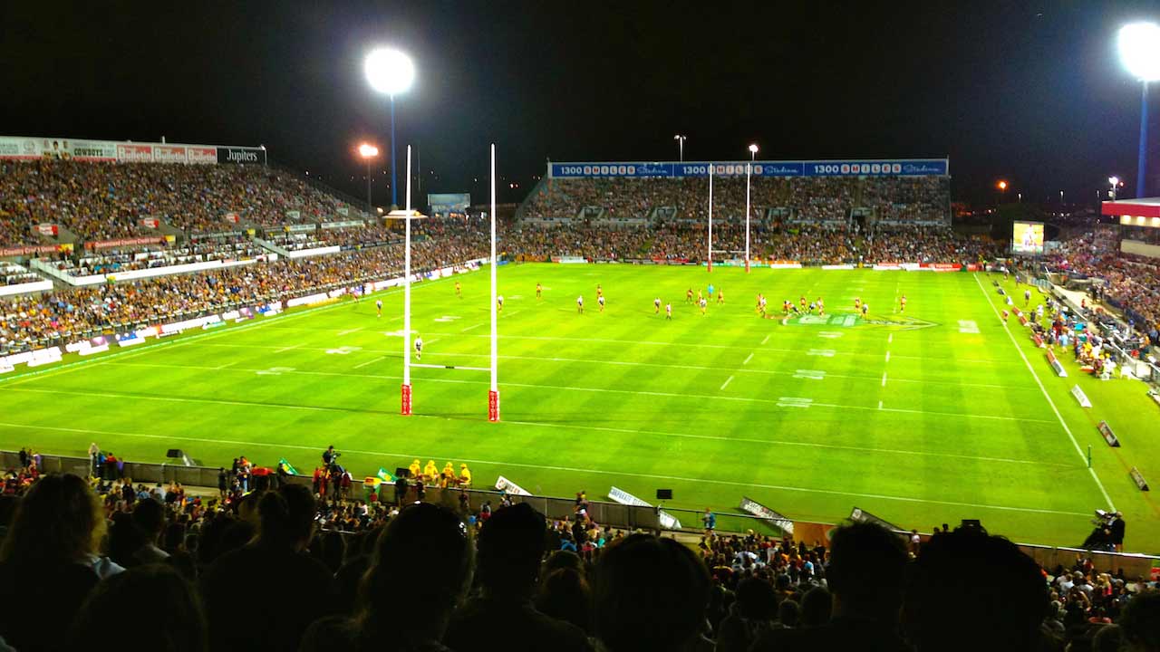 An illuminated football stadium packed with fans during a nighttime match