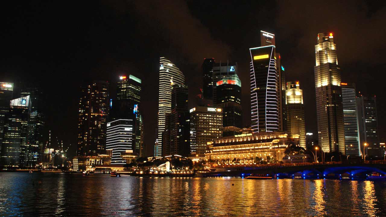 Nighttime illuminated skyline along the harbor in Singapore
