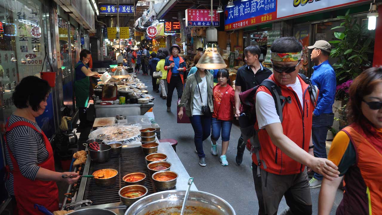 A busy laneway of shops and street food in Seoul